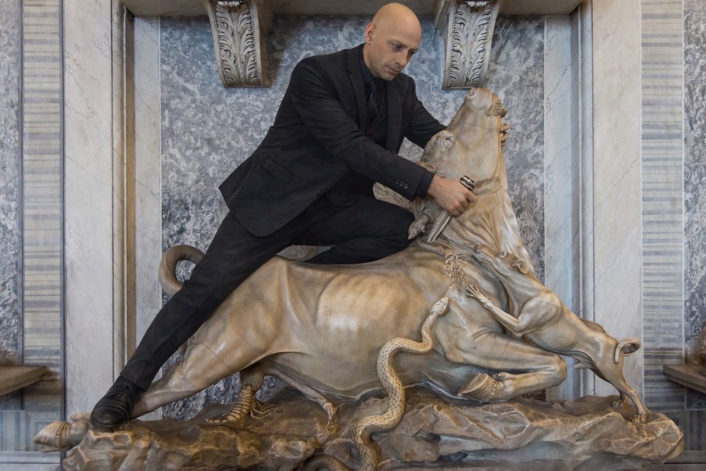 A person in a suit posed on a bull statue (marketing momentum)